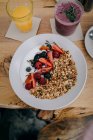 Joghurt mit Müsli, Erdbeeren, Himbeeren und Blaubeeren in Schüssel — Stockfoto