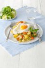 Potatoes, carrots, and leek ragout with fried egg and green salad — Stock Photo