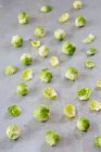 Strewn brussels sprouts on a metal sheet — Stock Photo