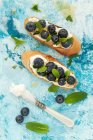 Crostini with mascarpone, blueberries, lemon zest and mint — Stock Photo