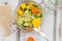 Quinoa salad with avocado, cucumber, tomatoes and mango in glass jar — Stock Photo