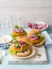 Carrot and chickpea burgers with red onion, coriander and lettuce — Stock Photo