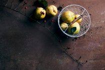 Vue de dessus des poires, du citron, des pommes de terre et de la glace sur une vieille table en pierre. — Photo de stock