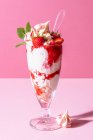 Strawberry sundae with ice cream, whipped cream, crushed meringue, strawberry sauce and mint — Stock Photo