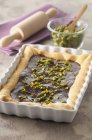 Chocolate tart with pistachios in a square-shaped baking dish — Stock Photo