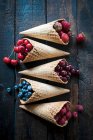 Diverses baies et cerises dans des cônes de crème glacée — Photo de stock