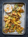 Roasted potatoes on baking tray with parsley and garlic — Stock Photo