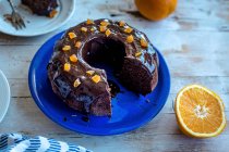Cutting chocolate bundt cake with coconut sugar and orange chocolate glaze — Stock Photo