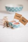Pink cream desserts in small bowls with names labels — Stock Photo