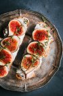 Figs slices and goat's cheese sandwiches on metal tray — Stock Photo