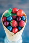 Fresh berries and cherries in an ice cream cone — Stock Photo