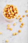Corn pops in a plastic tub and on a marble background — Stock Photo