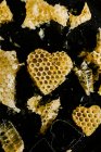 Favo de mel em forma de coração no fundo preto — Fotografia de Stock