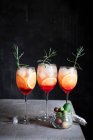 Aperol Spritz in glasses with rosemary and olives in glass jar — Stock Photo