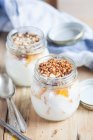 Joghurt mit Orangenstücken und gehackten Nüssen — Stockfoto