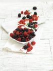 Свежие летние ягоды в чаше и рядом с ней — стоковое фото