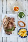Churrasco steak with side dishes (Criolla sauce, chimichurri sauce and potato wedges) — Stock Photo