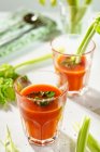 Glasses of tomato juice with celery and parsley — Stock Photo