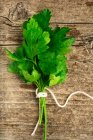 A bunch of smooth parsley on a wooden background (top view) — Stock Photo