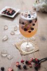 Біла Сангрія з ягодами у великому винному склі та льоду. — стокове фото