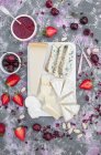 Cheese board, served with fresh fruits, strawberry jam, almonds and edible dried rose petals — Stock Photo