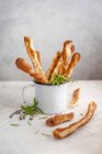 Herb breadsticks in an enamel cup — Stock Photo