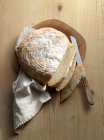 Una pagnotta di pane di patate, affettata su una superficie di legno — Foto stock