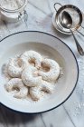 Vanilla horns with powdered sugar on an enamel plate — Stock Photo