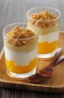 Layered desserts with orange, pear and speculoos biscuit crumbs — Stock Photo