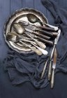Old silver cutlery on metal plate (top view) — Stock Photo