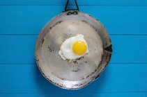 Un uovo fritto in una vecchia padella — Foto stock