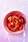In Scheiben geschnittene frische Erdbeeren mit Minzblättern in Schüssel mit Löffel — Stockfoto