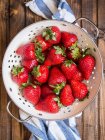 Fresh strawberries in an enamel colander — Stock Photo