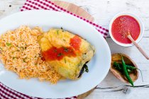 Chile Relleno: stuffed peppers with tomato sauce and red rice — Stock Photo