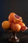 Oranges and blood oranges in ceramic bowl-stand — Stock Photo