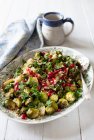 Roasted Brussels sprouts with quinoa, pecan nuts, pomegranate seeds and maple syrup — Stock Photo
