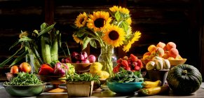 Fiori autunnali, verdure, cipolla, erbe, cavolo e spezie in un negozio di legno — Foto stock