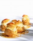 Profiteroles filled with cream and drizzled with caramel — Stock Photo