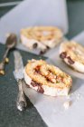 Rotolo di biscotti con ripieno di frutta e cioccolato su una pergamena bianca — Foto stock