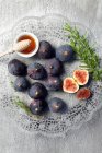 Fresh whole and halved figs with rosemary, honey in small bowl and wooden stick — Stock Photo