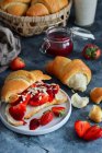 Croissants with fresh strawberries, jam and almonds — Stock Photo