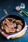 Pork ribs in a pan with garlic and fresh herbs — Stock Photo