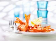 Cooked prawns with garlic, lemon juice and chili in olive oil — Stock Photo