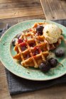 Round Belgian waffles with cherries, cherry sauce and vanilla ice cream — Stock Photo