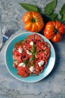 Salat mit Tomatensoße. Draufsicht auf einem Teller, auf rustikalem Hintergrund — Stockfoto
