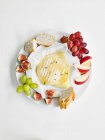 Cheese platter with fig, figs, walnuts and nuts on a white plate. top view — Stock Photo