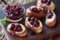 Cranberry sauce and fresh cheese on toasted bread — Stock Photo