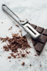 Chocolate squares and shavings with a vegetable peeler — Stock Photo