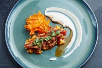 Flash fried tuna on salsa with vegetable crisps — Stock Photo