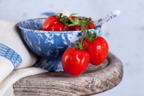 Pequenos tomates de ameixa em uma tigela de cerâmica — Fotografia de Stock